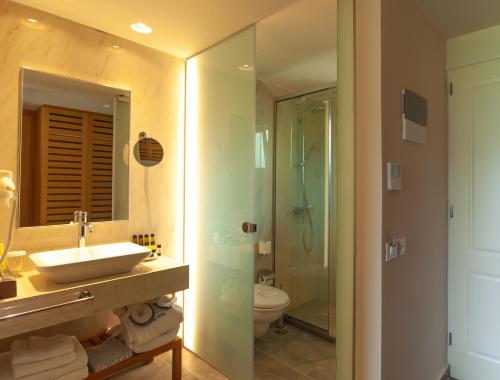 
a bathroom with a sink, toilet and shower at Pilot Beach Resort in Georgioupolis
