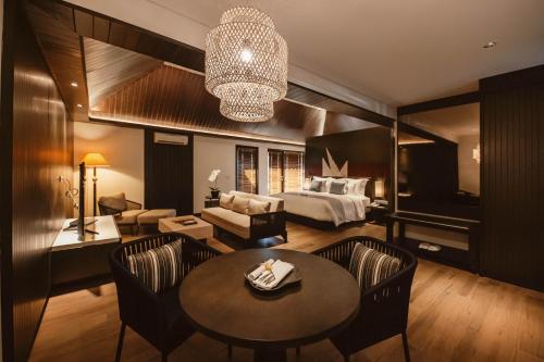 a hotel room with a bed and a living room at The Vira Bali Boutique Hotel & Suite in Kuta