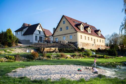 two children playing in the sand in front of a house at Gospodarstwo Agroturystyczne Kowalowe Wzgórze in Polanica-Zdrój