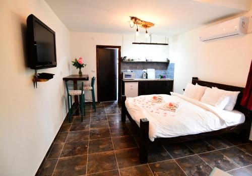 a bedroom with a bed and a tv on a wall at Tzlil Hateva in H̱osen