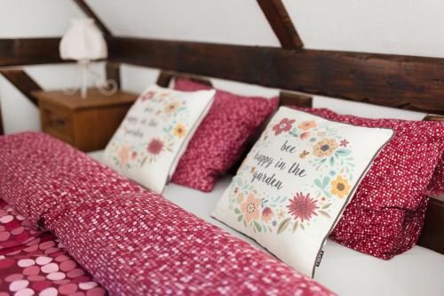 a bed with red and white pillows on it at Gospodarstwo Agroturystyczne Kowalowe Wzgórze in Polanica-Zdrój