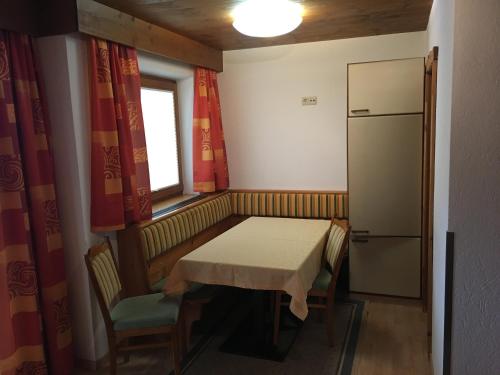 a small kitchen with a table and a refrigerator at Alpenspirit in Sölden