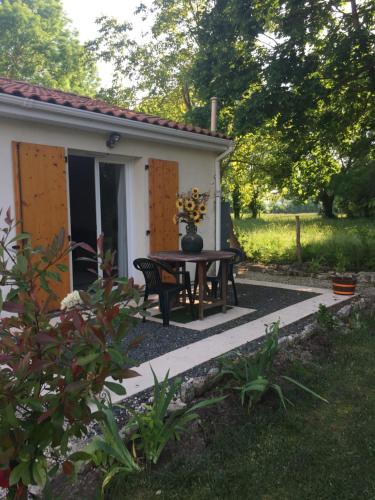 a patio with a table in front of a house at St Pasha in Paillé