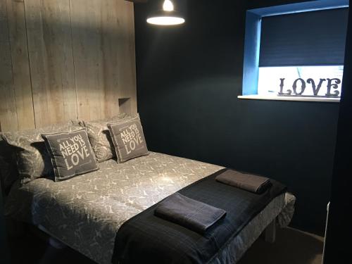 a bedroom with a bed with a window with the words love at Square House Bildeston High street in Ipswich