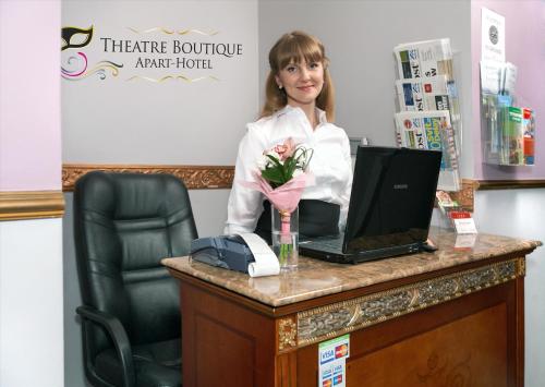 una donna in piedi alla scrivania con un computer portatile di Theatre Boutique Apartments a Kiev