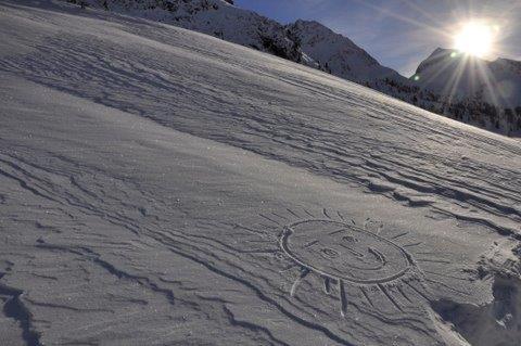 a drawing in the snow with the sun in the background at Ferienwohnung Artur Wieser in Sankt Jakob in Defereggen