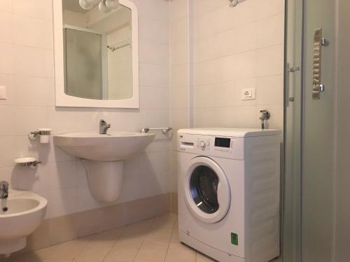 a bathroom with a washing machine and a sink at Residence Mirage in Grado