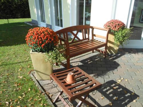 a bench and a pot of flowers next to a house at Landhaus Hammoor Stieper Gastronomie GmbH in Hammoor