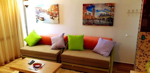 a living room with a couch with colorful pillows at City Apartments in Eilat