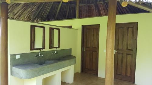 a bathroom with two sinks and two wooden doors at Migombani Camp in Mto wa Mbu
