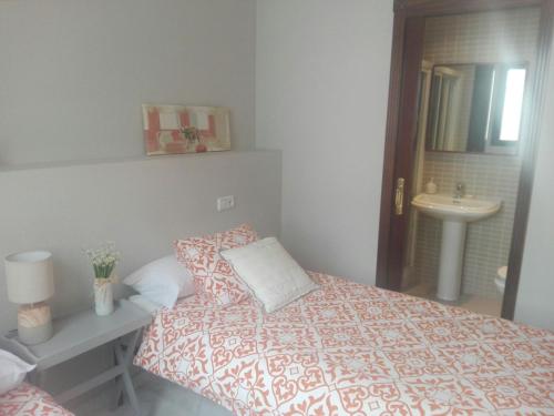 a small bedroom with a bed and a sink at Charming Villadarias M. Palace apartment in Antequera