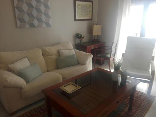 a living room with a couch and a coffee table at Charming Villadarias M. Palace apartment in Antequera