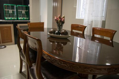uma mesa de jantar com cadeiras e uma taça de flores em ParmView Inn em Legazpi