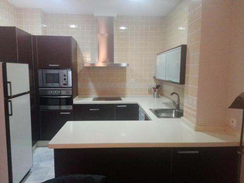 a kitchen with a white counter top and a sink at Charming Villadarias M. Palace apartment in Antequera