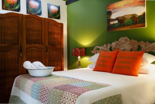 a bedroom with a bed with orange and green walls at The Farmers Cottage Bethulie in Bethulie