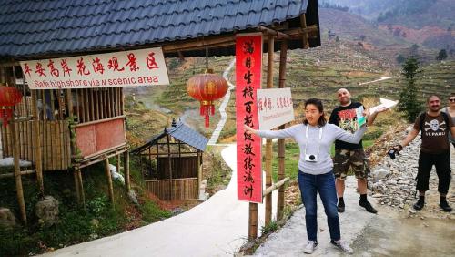 a woman standing next to a sign in a mountain at Longji Holiday Hotel in Longsheng
