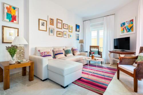 sala de estar con sofá blanco y TV en Genteel Home Alfalfa, en Sevilla