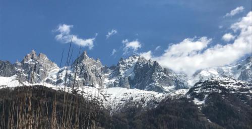 a snow covered mountain range with clouds in the sky at Appart'Hotel Aiguille Verte & Spa in Chamonix-Mont-Blanc