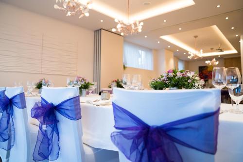a set of tables with blue bows on them at Hotel Goll Pforzheim-Niefern in Niefern-Öschelbronn