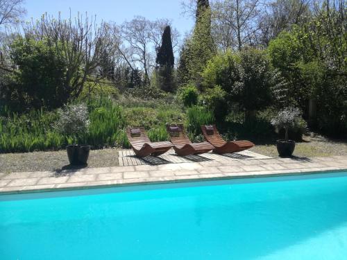 un groupe de chaises assises à côté d'une piscine dans l'établissement Mon Petit Soulié, à Loupia
