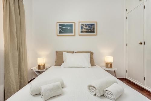 ラゴスにあるLagos Apartamento Praia Dona Anaのベッドルーム1室(白いベッド1台、ランプ2つ付)