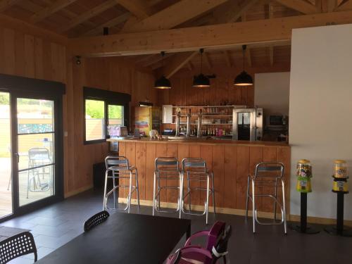 - une cuisine avec trois tabourets de bar dans une pièce dans l'établissement Camping Mussonville, à Soulac-sur-Mer