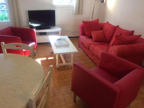 a living room with a red couch and a table at Mer et Soleil in La Ciotat