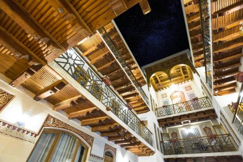 um edifício com pisos de madeira e varandas com luzes em Boutique Safiya em Bukhara