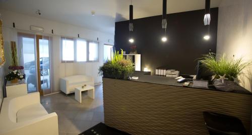 eine Lobby mit einer Theke mit Topfpflanzen darauf in der Unterkunft Lacroma Aparthotel in Grado