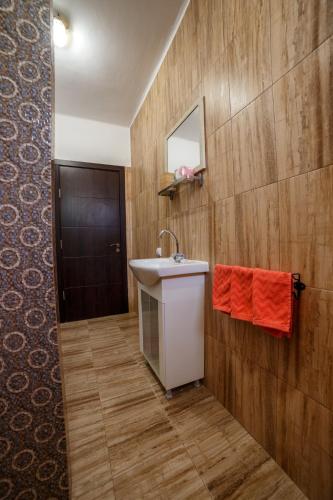 a bathroom with a sink and orange towels on the wall at Villa Rose in Belogradchik