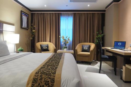 ナゴヤにあるナゴヤ マンション ホテル ＆ レジデンスのベッド、デスク、ノートパソコンが備わるホテルルームです。