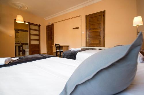 a hotel room with a bed, chair, and nightstand at La Posada de La Casona de Sarria in Sarria