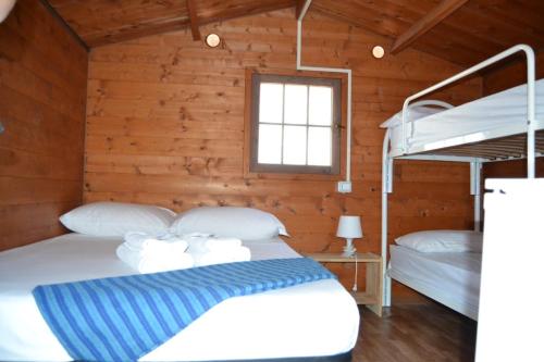 1 Schlafzimmer mit 2 Etagenbetten in einer Hütte in der Unterkunft Policoro Village Hotel in Policoro