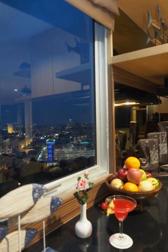 a bowl of fruit on a table in front of a window at Nagoya Mansion Hotel and Residence in Nagoya