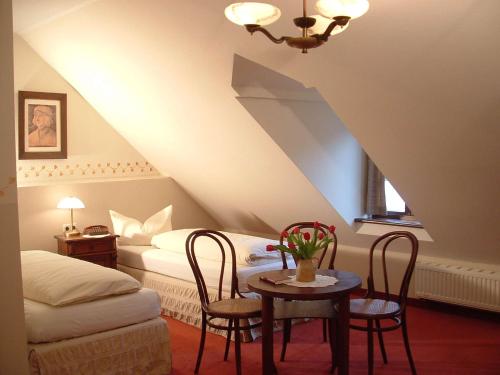 ゲルリッツにあるHotel und Gasthof Dreibeiniger Hundのベッドルーム1室(ベッド1台、テーブル、椅子付)