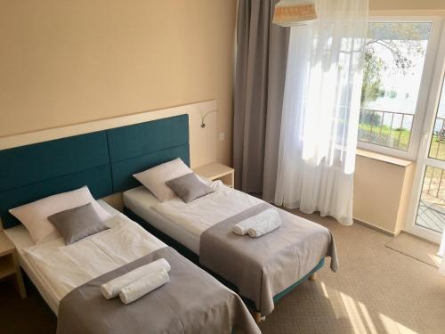 a hotel room with two beds and a window at Neptun in Międzychód
