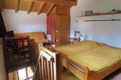 a bedroom with two beds and a table and a chair at Ul Rüstic a Monte in Casima