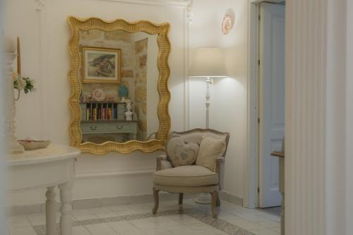 una stanza con una sedia e uno specchio di TAM Vacanze B&B a Cinisi