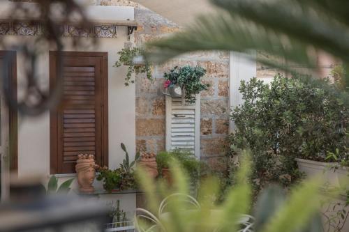 a house with two doors and potted plants on it at TAM Vacanze B&B in Cinisi