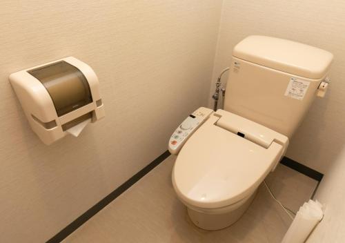 a bathroom with a toilet with a toilet paper dispenser at Morino Hotel in Kiso