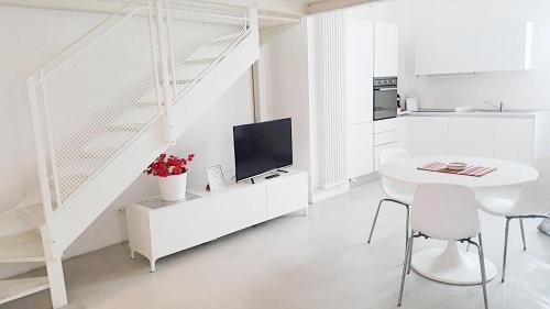 ボローニャにあるLe Suite di Luna Rossellaの白いテーブルと白い階段のある白いキッチン
