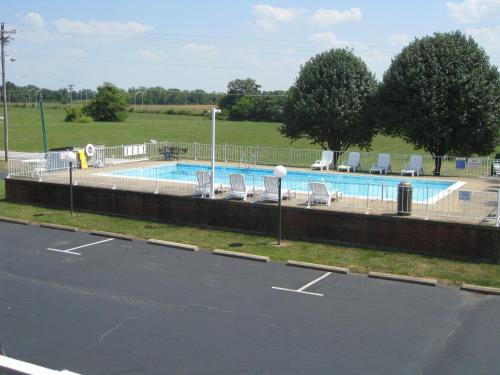 a swimming pool with chairs next to a parking lot at Bryce Inn in Smiths Grove