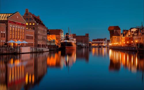 a view of a city with a river at night at Apart Neptun in Gdańsk
