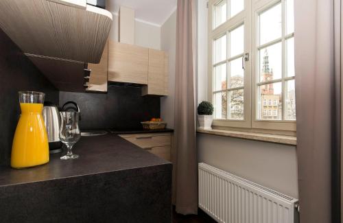 a kitchen with a counter with a yellow vase at Apart Neptun in Gdańsk