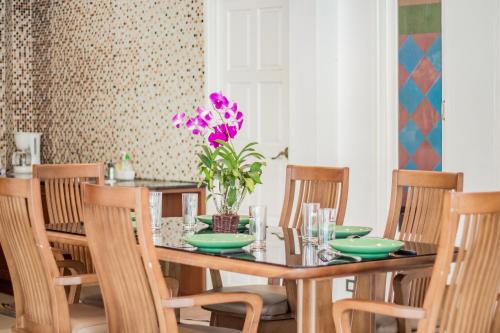 a dining room with a wooden table and chairs at TEWAREE VILLA - PATTAYA HOLIDAY HOUSE WALKING STREET 4 bedrooms in Pattaya South