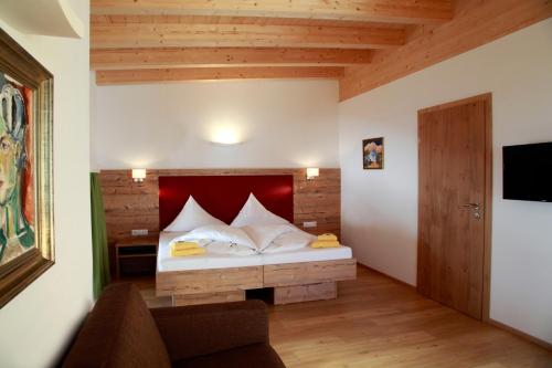 a bedroom with a bed with a red headboard at Alpenhotel Seiler in Kühtai