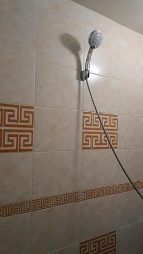 a shower with a shower head on a tile wall at Happy beach in Varna City