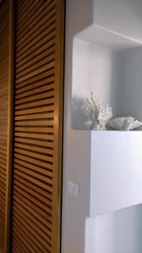 a white shelf with a plant on top of it at Casa Mirella in Favignana