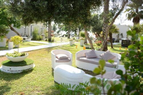 a garden with two white couches and a bowl at El Yam in Netanya