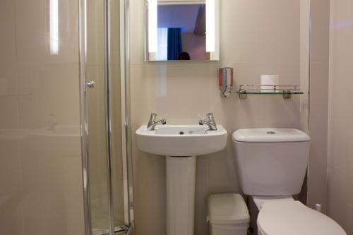 a bathroom with a toilet and a sink and a shower at Westpoint Hotel in London